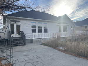 Back of house featuring a patio area and roof with shingles