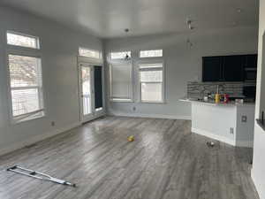 Unfurnished living room with dark wood finished floors and baseboards