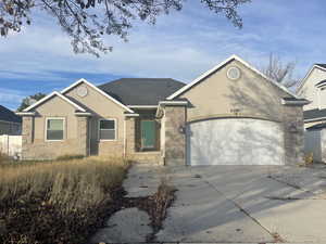 Single story home featuring driveway, a garage, and stucco siding