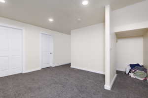 Newly finished basement featuring a family room, 3/4 bathroom, bedroom and storage under stairs.
