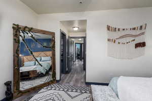 Primary bedroom with LVP floors and custom paint.