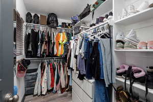 Large primary bedroom walk-in closet featuring ample storage and lots of natural light.