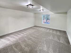 Primary Bedroom featuring tall baseboards, cozy plush carpet, ample lighting, and convenient bathroom
