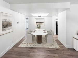VIRTUALLY STAGED-Dining room featuring fresh wood style floors and artistic ceiling