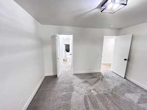 Second Bedroom featuring tall baseboards, cozy plush carpet, ample lighting, and convenient bathroom access through a walk-in closet