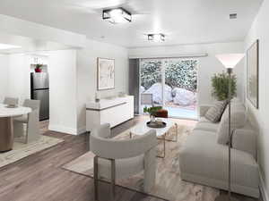 VIRTUALLY STAGED-Living room featuring ample natural lighting, fresh wood style flooring and newly painted timeless two-toned paint with large, modern baseboards