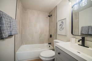 Bathroom featuring shower / tub combination, vanity, and a textured ceiling