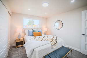 Bedroom featuring dark carpet, recessed lighting, and a closet