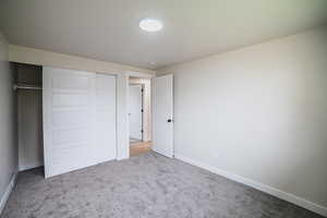 Unfurnished bedroom with a closet and carpet