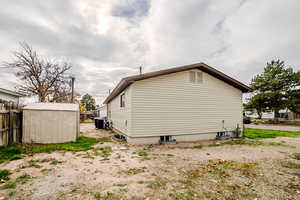 View of property exterior featuring a storage unit and a central air condition unit