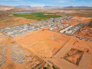 Aerial view of property and surrounding area featuring nearby suburban area and a water and mountain view