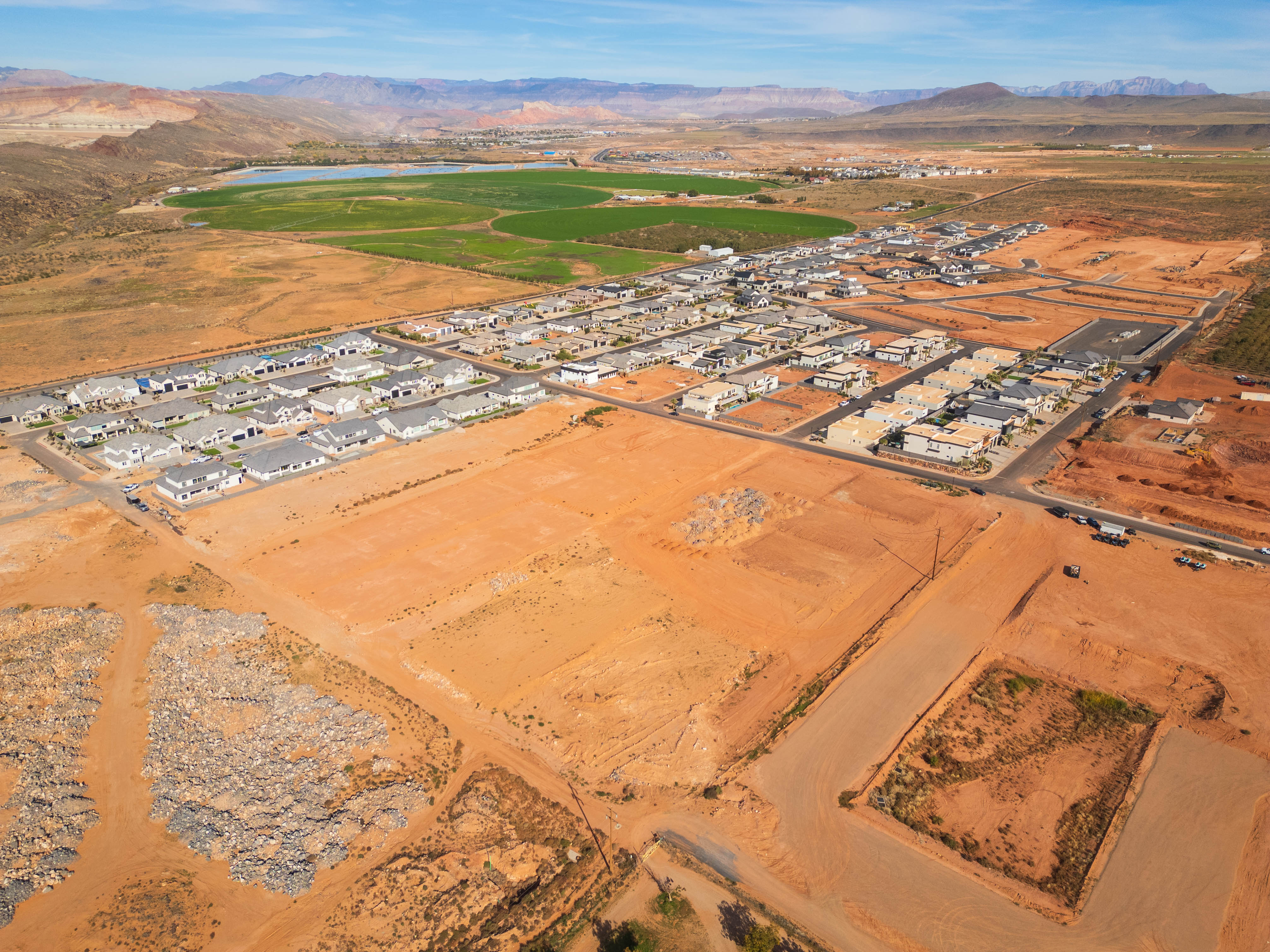 Aerial view of property and surrounding area featuring nearby suburban area and a water and mountain view