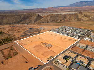 Aerial view of property and surrounding area featuring a mountainous background and property boundaries highlighted
