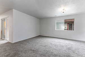 Spare room with carpet flooring and a textured ceiling