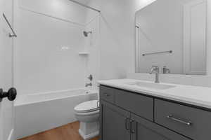 Basement bedroom private bathroom featuring light wood finished floors, shower / tub combination, and vanity