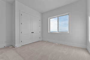 Bedroom with light carpet, closet, mountain view