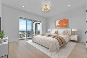 Master Suite bedroom with light wood finished floors, access to outside deck, recessed lighting, chandelier, and valley mountain views