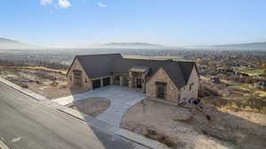 View of front of house with stone siding, driveway, and mountain view