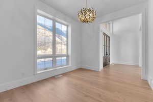 Office area featuring light wood finished floors, chandelier, and a mountain view