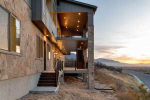 View of property rear exterior with two levels of decks, stone siding, with valley and  mountain views
