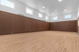 Sports court featuring regulation sized pickleball court and half-court basketball,  wainscoted wood walls, sport court flooring, and wall mounted mini splits