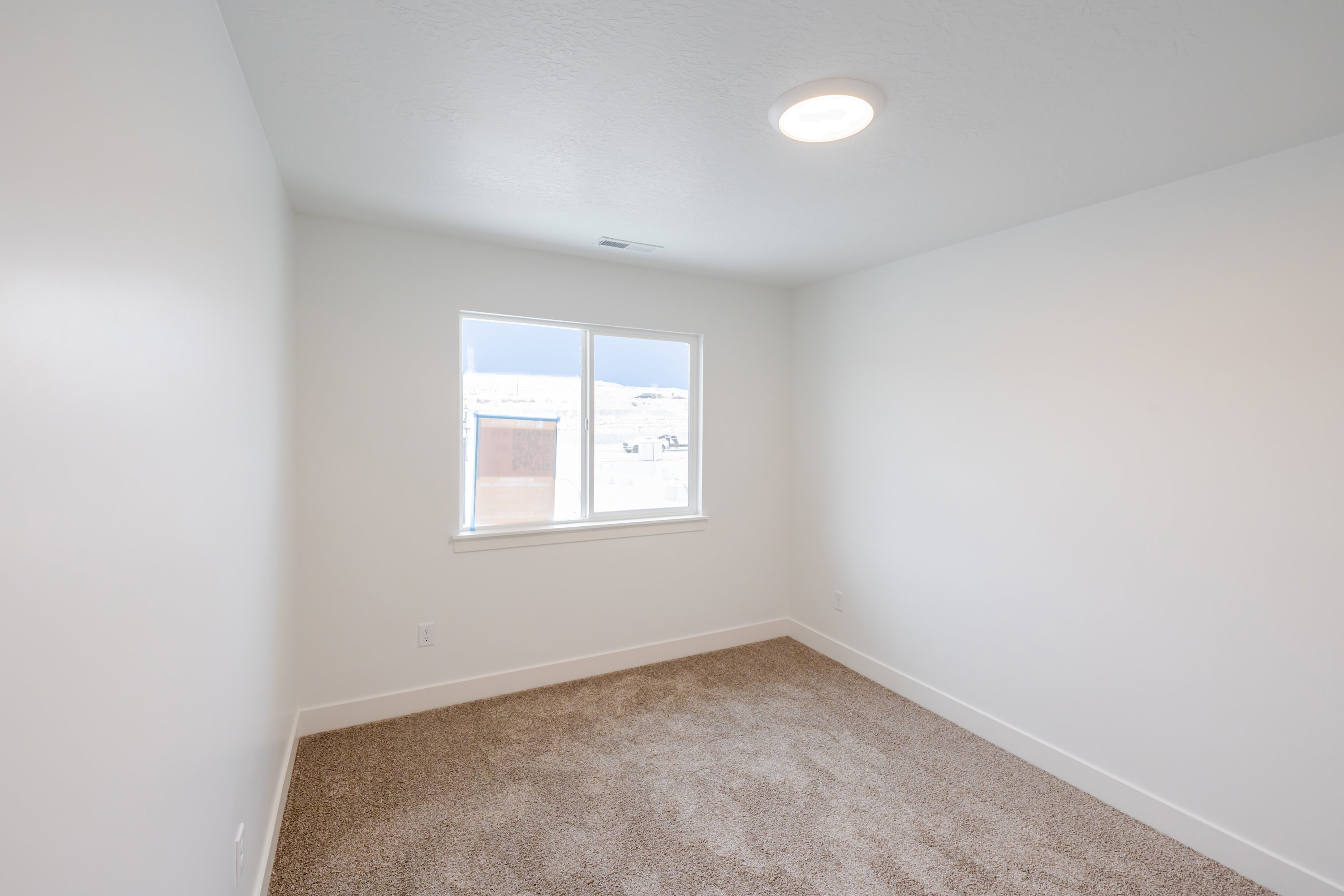 Empty room featuring baseboards and light colored carpet