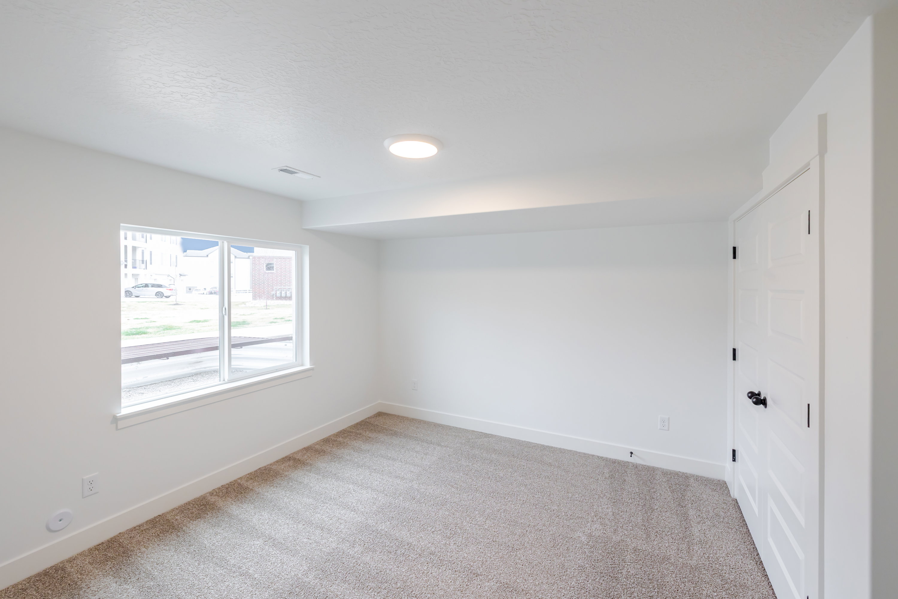 Spare room featuring baseboards and light carpet