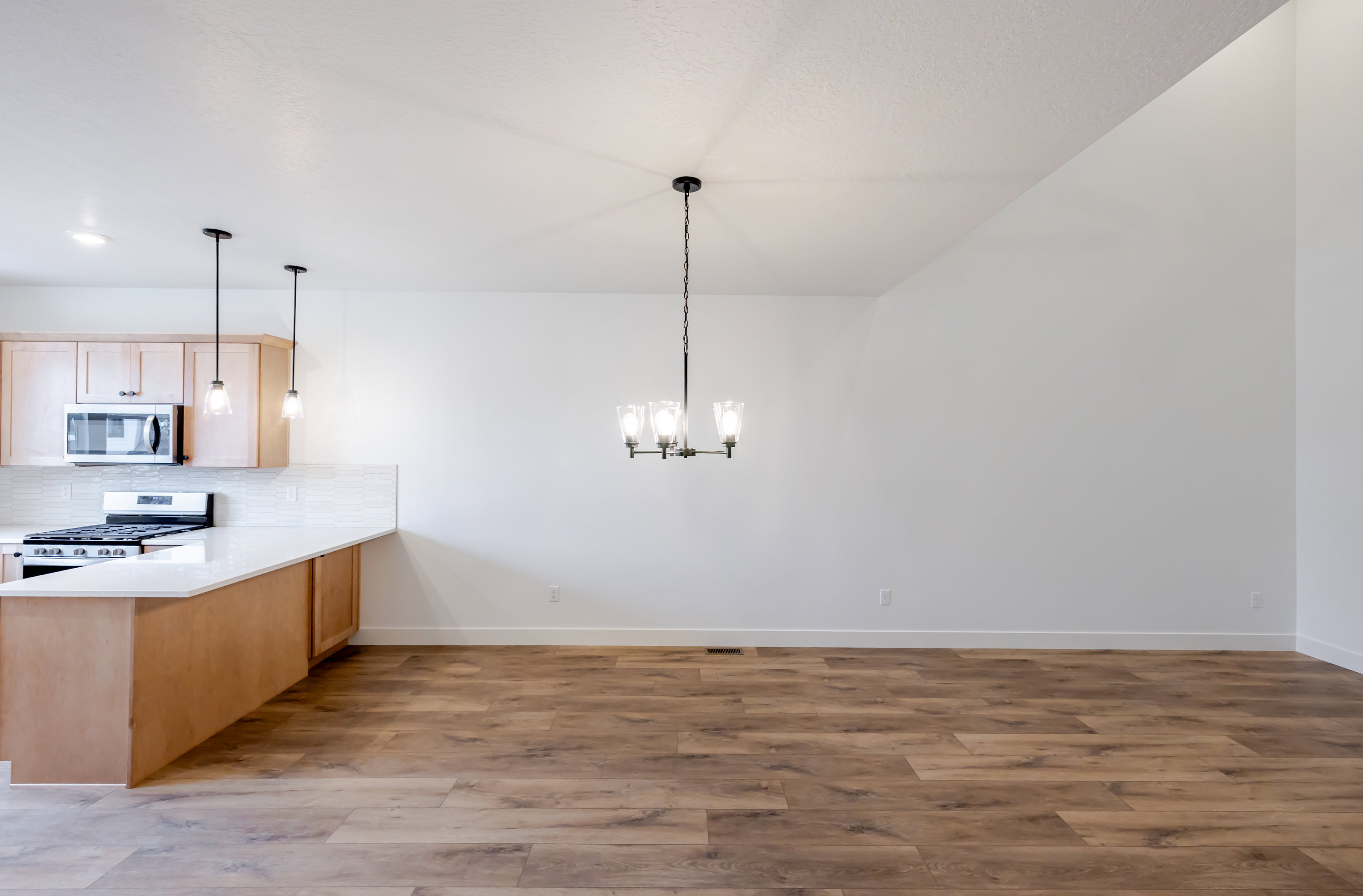 Kitchen with a peninsula, light wood finished floors, stainless steel appliances, and light wood finish cabinets