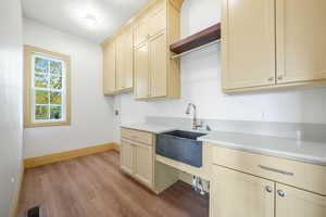 Kitchen with cream cabinets, light wood-type flooring, open shelves, and decorative backsplash