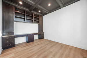 Unfurnished office featuring built in study area, light wood-style flooring, recessed lighting, beam ceiling, and coffered ceiling