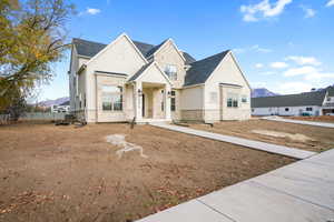French provincial home with stone siding, a mountain view, and stucco siding