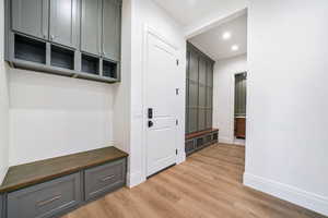 Mudroom with light wood finished floors and recessed lighting