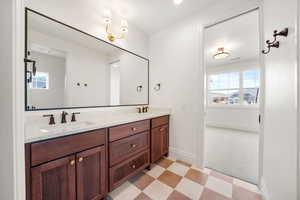 Bathroom featuring double vanity and light flooring