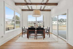 Dining room with coffered ceiling, light wood-type flooring, and recessed lighting