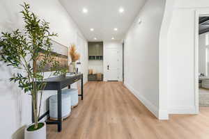 Hall with recessed lighting and light wood-style flooring