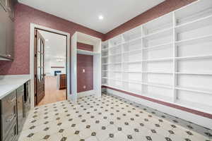 Interior space featuring built in features, wallpapered walls, recessed lighting, and light floors