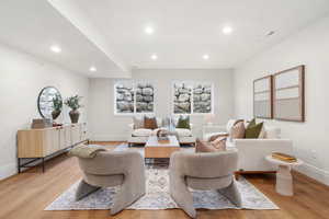 Living area with light wood-style floors and recessed lighting