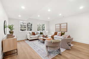 Living room with light wood-style flooring and recessed lighting