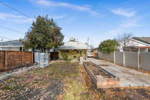 Rear view of house with a garden and a fenced backyard