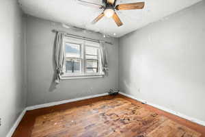 Unfurnished room featuring wood-type flooring and a ceiling fan