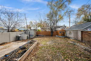 Fenced backyard with a shed and a garden