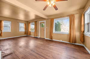 Entryway featuring wood-type flooring, plenty of natural light, ceiling fan, and beam ceiling
