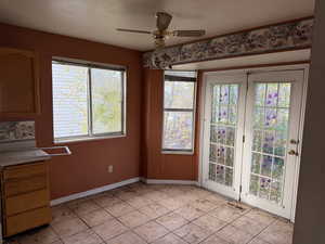 Unfurnished dining area with a ceiling fan and light tile patterned floors