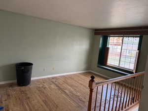 Spare room featuring wood-type flooring and baseboards