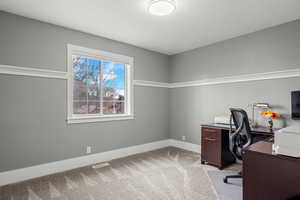 Home office featuring baseboards and light colored carpet