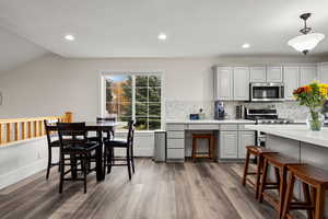 Kitchen featuring recessed lighting, gray cabinets, dark wood-type flooring, and backsplash