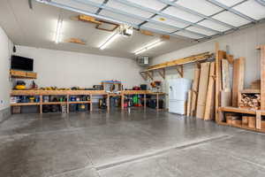 Garage featuring a heating unit, built in workbench and storage, a workshop area, and a garage door opener