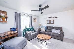 Living room with carpet and ceiling fan