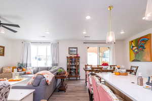 Living room featuring light wood-type flooring, plenty of natural light, and recessed lighting