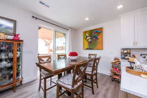 Dining space with light wood-style flooring and recessed lighting